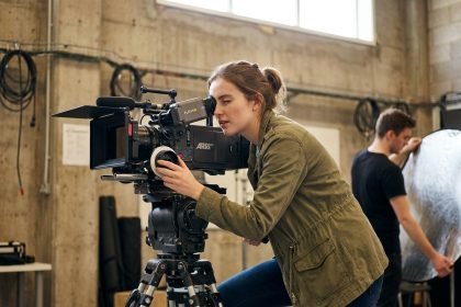 Étudiante en cinéma derrière une caméra professionnelle dans un studio universitaire après le bac