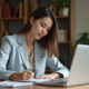 Jeune femme au bureau prenant des notes dans un environnement moderne
